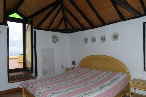 Bedroom with high beamed ceiling and marble heating
