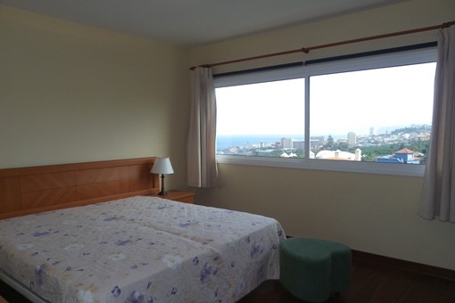Large master bedroom with wide windows to the ocean