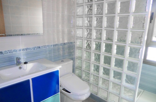 Another bathroom with a self-cleaning toilet and rain shower